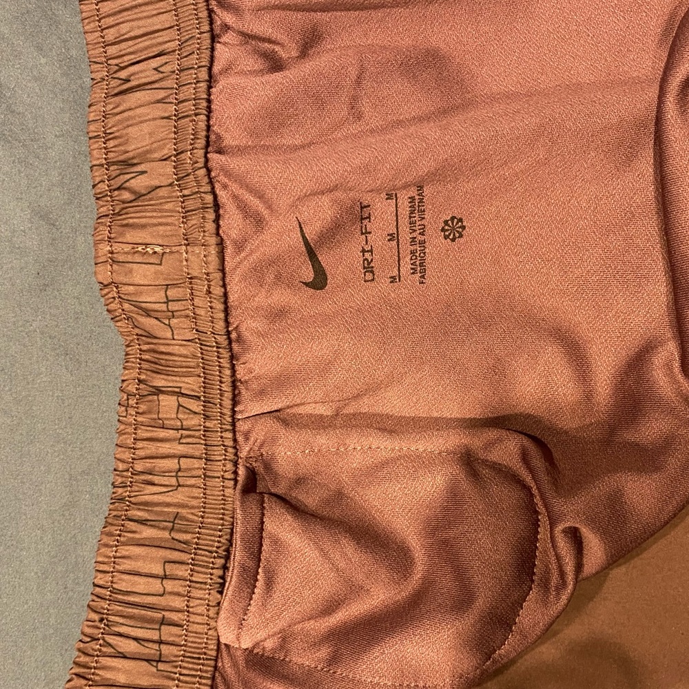 NIKE running shorts. Red-purple. Pocket in back and in back of liner. Size med